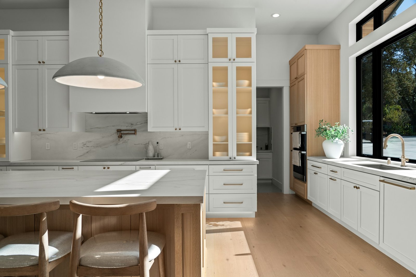 Cuisine rénovée lumineuse, avec îlot central et meubles blancs